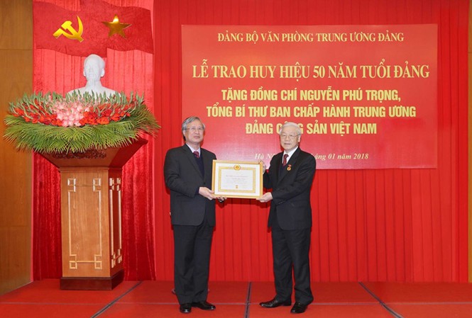 Tổng Bí thư Nguyễn Phú Trọng nhận Huy hiệu 50 năm tuổi Đảng Ông Trần Quốc Vượng, Ủy viên Bộ Chính trị, thành viên Thường trực Ban Bí thư, Chủ nhiệm Ủy ban Kiểm tra T.Ư trao Huy hiệu 50 năm tuổi Đảng tặng Tổng Bí thư Nguyễn Phú Trọng. Ảnh: TTXVN.