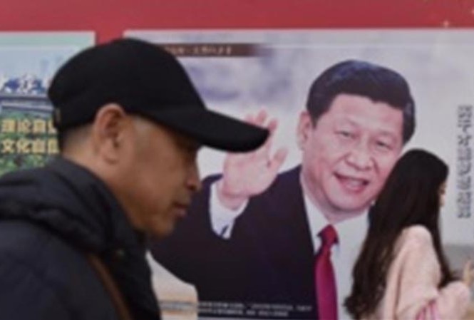 Bệ đỡ để cá nhân cầm quyền không giới hạn Người dân đi qua tấm poster hình Tổng bí thư, Chủ tịch Trung Quốc Tập Cận Bình trên một tuyến phố ở Bắc Kinh ngày 26/2. Ảnh: Getty Images.
