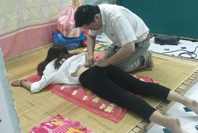 'Lương y chui' phán bệnh, moi tiền Ông Long kiểm tra cho một thiếu nữ trong “phòng kỹ thuật” luộm thuộm, nhếch nhác. Ảnh: T.T