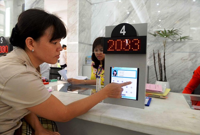 Tinh giản hơn 2.000 cán bộ, viên chức mỗi năm Người dân bấm nút chấm điểm cán bộ tại trụ sở UBND quận 1.