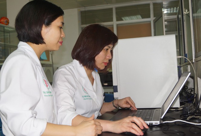 Chinh phục đỉnh cao y học Trung úy Đào Thanh Quyên (bên trái) và thượng úy Trần Thị Thanh Huyền, khoa Sinh học phân tử, Bệnh viện T.Ư Quân đội 108 đang phân tích và thảo luận kết quả xét nghiệm chẩn đoán vi khuẩn gây nhiễm khuẩn huyết. Ảnh: Nguyễn Minh.