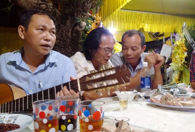 Đừng kiếm thiền sư Tác giả Bùi Long ôm đàn trong đám tang thi sĩ Trần Vàng Sao. Ảnh: Trần Tuấn.