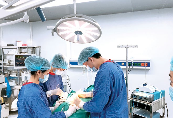 Sự lựa chọn liều lĩnh Bác sĩ Hậu (bên phải) đang mổ u tuyến giáp cho bệnh nhân.