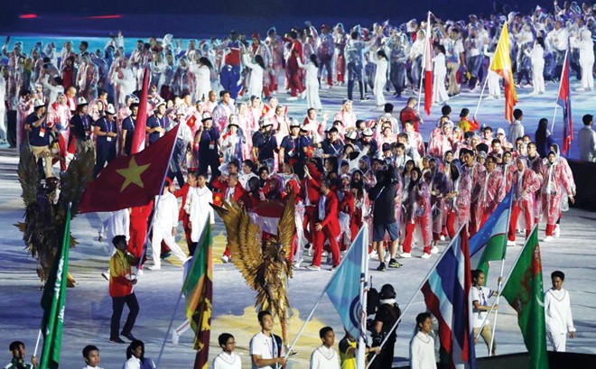 Vì sao đoàn Việt Nam không dự lễ bế mạc Asiad 2018? Tình nguyện viên nước chủ nhà rước quốc kỳ Việt Nam tiến vào sân VĐV Bung Karno trong lễ bế mạc Asiad 2018