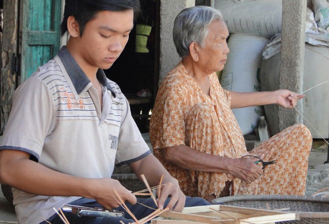Suất học bổng đổi đời Hình ảnh em Nguyễn Thanh Nhân (8 năm trước) cùng ngoại đan lát tre mây kiếm tiền ăn học đăng trên báo Tiền Phong. Ảnh: Nguyễn Thành