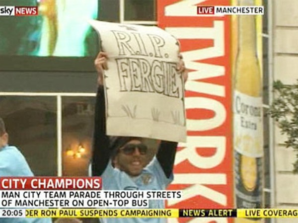 Tevez khoe 'bia mộ' của HLV Ferguson Tevez hoan hỉ giương cao "bia mộ" trên xe bus.