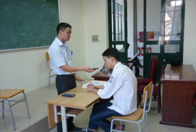 Phó Chủ tịch Hội người mù huyện đi thi đại học Thí sinh Hoàng Minh Quang đang làm bài thi qua máy ghi âm