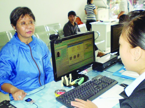Làm thủ tục qua vân tay Người dân làm thủ tục khai báo thông tin cá nhân lần đầu tại UBND phường Bến Thành. Ảnh: T.L
