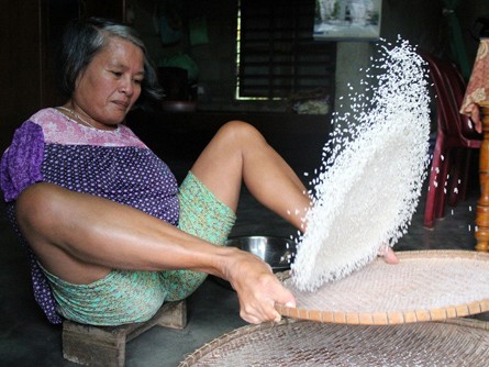 Người phụ nữ sàng gạo bằng chân để kiếm sống Người phụ nữ sàng gạo bằng chân để kiếm sống