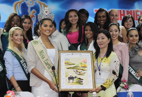 Người đẹp Miss Earth thăm khu xử lý rác Miss Earth 2009 nhận bức tranh từ đại diện Hội liên hiệp phụ nữ huyện Bình Chánh trao tặng