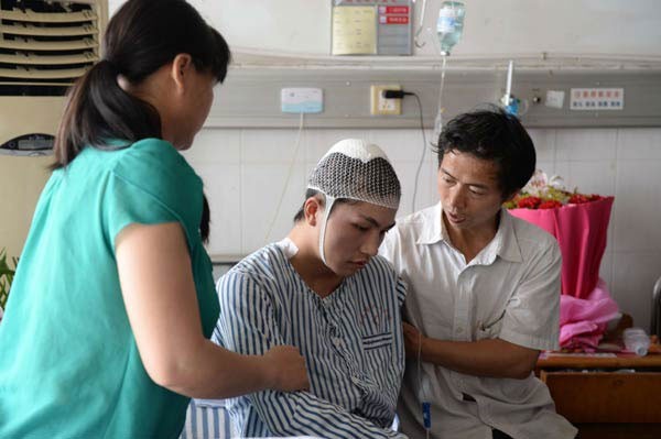 Hai nam sinh vào thẳng đại học nhờ ngăn chặn sát thủ Bố mẹ Liu Yanbing chăm sóc con trai tại bệnh viện. Ảnh: Tân Hoa Xã