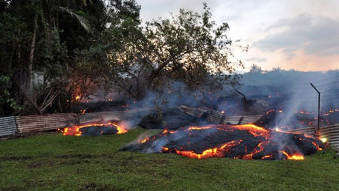 Núi lửa Kilauea đốt cháy nhà dân Đá nóng chảy trào ra từ núi lửa, tràn vào thị trấn Pahoa hôm 28/10. Ảnh: USGS