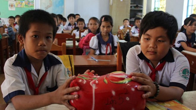 Nuôi heo đất tiếp sức trò nghèo đến trường Các em học sinh lớp 5/2, Trường tiểu học Vĩnh Hòa (Ba Tri, Bến Tre) nuôi heo đất giúp các bạn nghèo trong lớp.