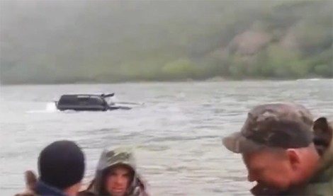 Ôtô bơi bì bõm trên hồ nước Chiếc SUV xuất hiện từ xa phía lòng hồ. Ảnh từ video.