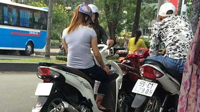 Nhộn nhịp “chợ” mại dâm di động lớn nhất Sài Gòn Hai cô gái bán dâm dừng xe cạnh một thanh niên làm nhiệm vụ canh chừng. Ảnh: HT.