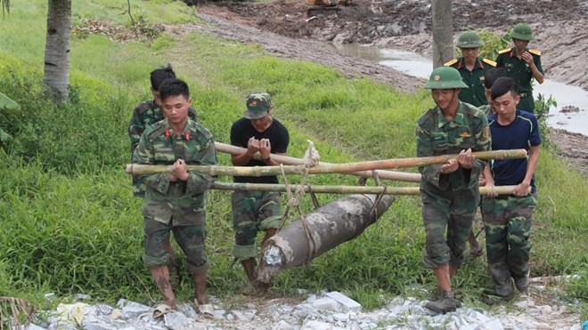 Phát hiện bom nặng 250 kg khi đào ao Lính công binh di dời quả bom khỏi khu vực sản xuất của người dân. Ảnh: T.L.