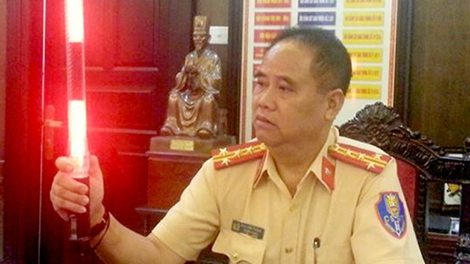 Cảnh sát giao thông Hà Nội có trang phục và gậy chỉ huy đặc biệt Đại tá Đào Vịnh Thắng giới thiệu về chiếc gậy điều khiển giao thông được gắn đèn led. Ảnh: Phương Sơn