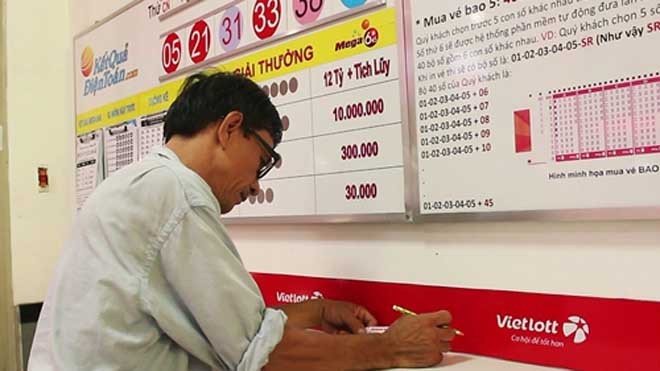 Vé số truyền thống than ế ẩm Một người chơi đang chọn mua 'xổ số kiểu Mỹ'. Ảnh: Phương Đông