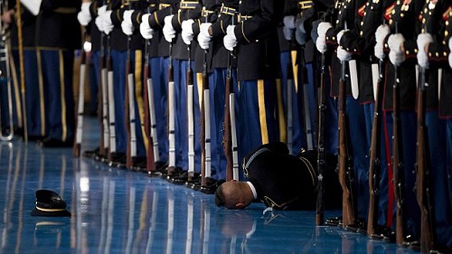 Lý do lính danh dự Mỹ đứng im khi đồng đội ngất trước mặt Obama Thành viên đội danh dự Mỹ ngất xỉu trong lễ từ biệt của Obama. Ảnh: AFP