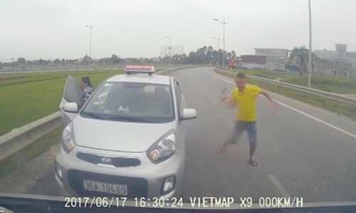 Truy tìm tài xế taxi chạy ngược chiều, rút gậy sắt doạ người đi đường Tài xế taxi hung hãn vung gậy sắt định hành hung lái xe khách. Ảnh cắt từ clip.