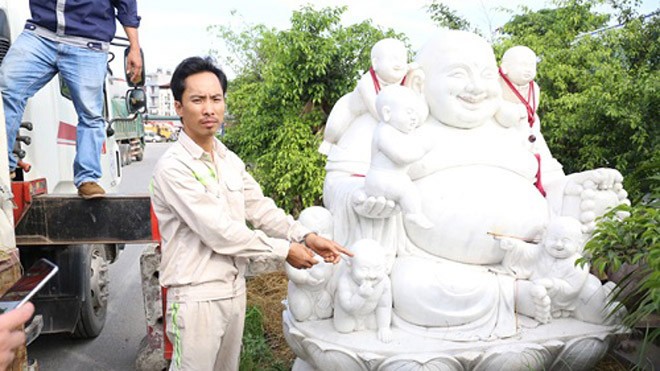 Dùng xe cẩu ăn trộm tượng Phật mang về quê thờ cúng Hoan bên cạnh bức tượng Phật Di Lặc. Ảnh: Công an cung cấp.