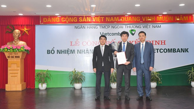 Lễ công bố quyết định bổ nhiệm nhân sự cấp cao Vietcombank Chủ tịch HĐQT Vietcombank Nghiêm Xuân Thành (bên trái) và Tổng Giám đốc Vietcombank Phạm Quang Dũng (bên phải) trao Quyết định và tặng hoa chúc mừng Ông Eiji Sasaki được bổ nhiệm là Thành viên Hội đồng quản trị kiêm Phó Tổng Giám đốc Vietcombank