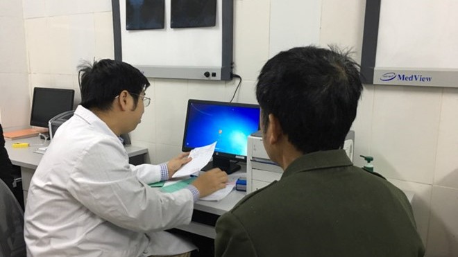 Căn bệnh... gió thổi qua cũng gây đau dữ dội Bác sĩ Nguyễn Trần Trung khám bệnh cho bệnh nhân gout. Ảnh: HQ.