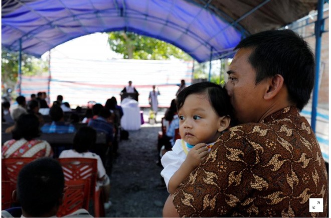 Thảm họa kép ở Indonesia: Số người chết lên hơn 1.700 Nhiều người tới cầu nguyện tại một nhà thờ ngoài trời tại phía nam Sulawesia với mong muốn tìm kiếm được người thân. Ảnh: Reuters