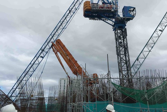 Doanh nghiệp mâu thuẫn, nguy hiểm rình rập công trường Hai chiếc cẩu bị gãy sau bão vẫn lơ lửng trên đầu người dân. Ảnh: P.T