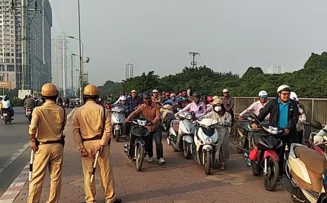Vì sao đoàn người liều lĩnh dắt xe ngược chiều trước mặt CSGT? Hàng trăm người dắt xe trên vỉa hè để tránh ách tắc giao thông. Ảnh: M.Đ