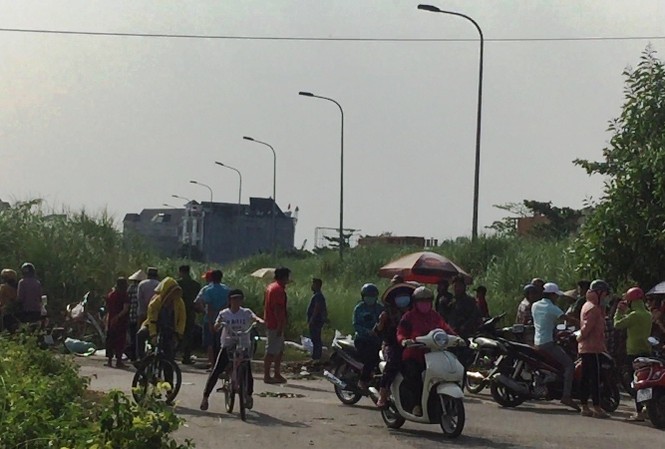 Thi thể cháy đen trong bãi đất trống ở Sài Gòn Nhiều người dân theo dõi công an làm việc.