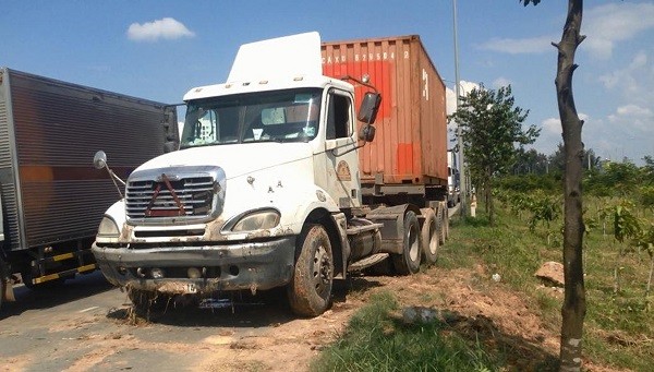 Tông sập trụ đèn, container lao đầu xuống mương Chiếc xe container sau khi được kéo lên bờ.