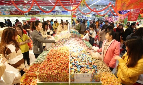 Siêu thị ngày giáp Tết thưa khách hơn mọi năm Mặt hàng bánh kẹo ngày Tết được nhiều khách hàng quan tâm và cũng có nhiều chương trình khuyến mại. Ảnh: Ngọc Thành
