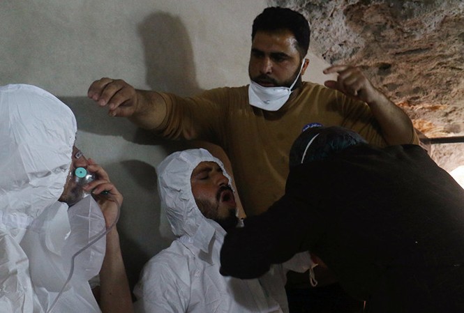 16 nhà khoa học Syria bị trừng phạt vì ‘sản xuất vũ khí hóa học’ Hai người đàn ông được chăm sóc y tế, thở bằng mặt nạ oxy tại hiện trường vụ tấn công bằng vũ khí hóa học ở Idlib hôm 4/4. Ảnh: Reuters
