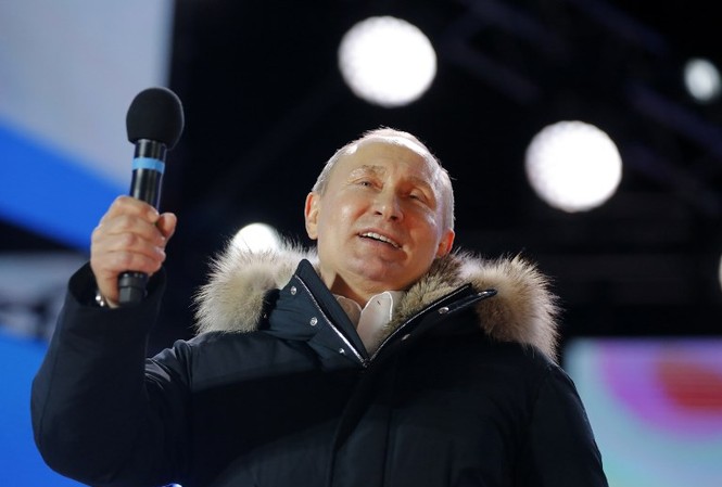 Ông Putin giành 76% số phiếu bầu, chắc chắn tái cử Tổng thống Ông Putin phát biểu trong cuộc mít tinh kỷ niệm 4 năm ngày Crimea sáp nhập Nga tại Quảng trường Manezgnaya ở Moscow. Ảnh: AFP