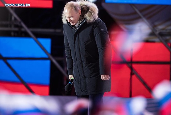 Báo Mỹ gọi ông Putin là 'hiện thân cho sức mạnh hồi sinh của nước Nga' Tổng thống Nga Vladimir Putin cúi chào người dân Nga tại Moscow trong một cuộc mít tinh diễn ra tối 18/3. Ảnh: Tân Hoa Xã