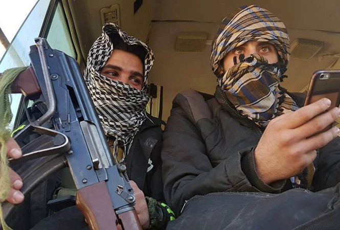 Phiến quân giao nộp 30 xe bọc thép cho quân chính phủ Syria Phiến quân rời khỏi Douma hôm 1/4. Ảnh: Reuters