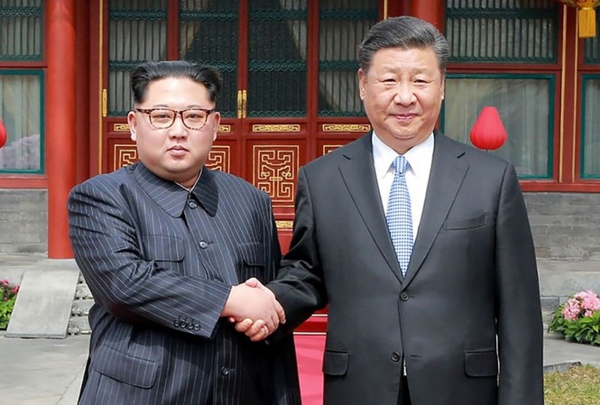 Hàn Quốc: Ông Kim có thể gặp ông Tập trên đường đến Singapore Chủ tịch Triều Tiên Kim Jong-un bắt tay Chủ tịch Trung Quốc Tập Cận Bình trong cuộc gặp cuối tháng Ba. Ảnh: SCMP