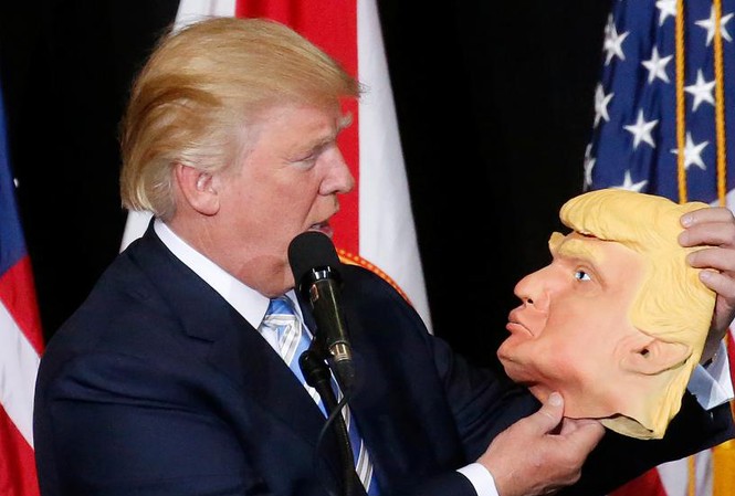 Tổng thống Obama, bà Hilary và ông Trump xuất hiện trước bầu cử Mỹ Ông Donald Trump, ứng viên đảng Cộng hòa, cầm trên tay chiếc mặt nạ hình ông tại điểm vận động tranh cử ở Sarasota, Florida tối ngày 7/11 (giờ địa phương).