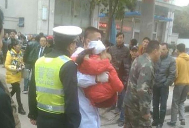 Người đàn ông cầm rìu chém 7 học sinh tiểu học Các nhân viên y tế đưa một em nhỏ bị thương ở đầu lên xe cấp cứu.