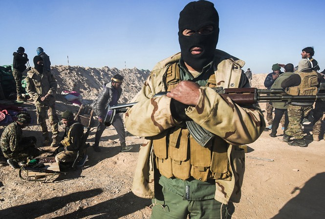 Phát hiện hố chôn hàng trăm người gần Mosul Một thành viên của lực lượng bán quân sự Hashed al-Shaabi.