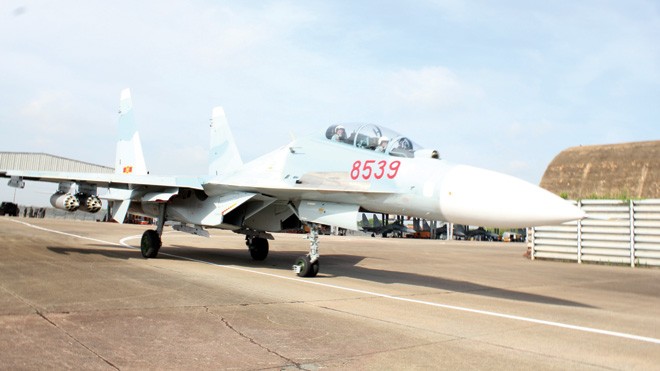 Xem SU 30MK2 'tiêu diệt mục tiêu' Su 30MK2 với 4 thùng phóng rocket dưới 2 cánh máy bay lăn bánh ra đường băng. Ảnh: Văn Thành