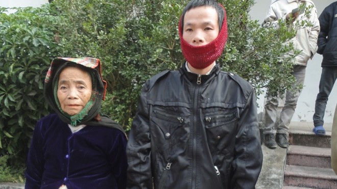Tuổi già, thương tật làm trụ cột gia đình Bà Thịnh, anh Nhày đến nhận quà tết tại huyện Như Xuân. Ảnh: K.N