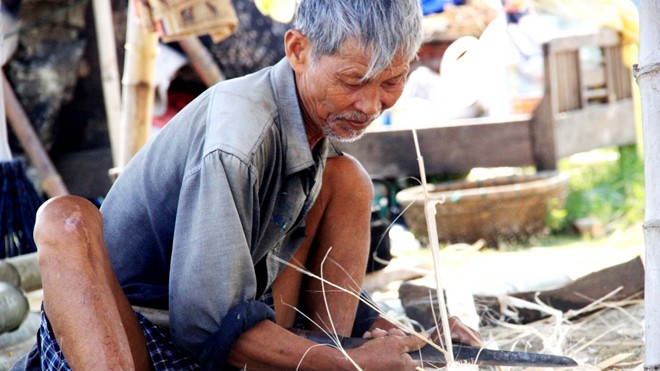 Thuyền thúng xuất ngoại Lão Liêm miệt mài gắn bó với nghề đan thuyền thúng thủ công. ẢNH: NGUYỄN HUY