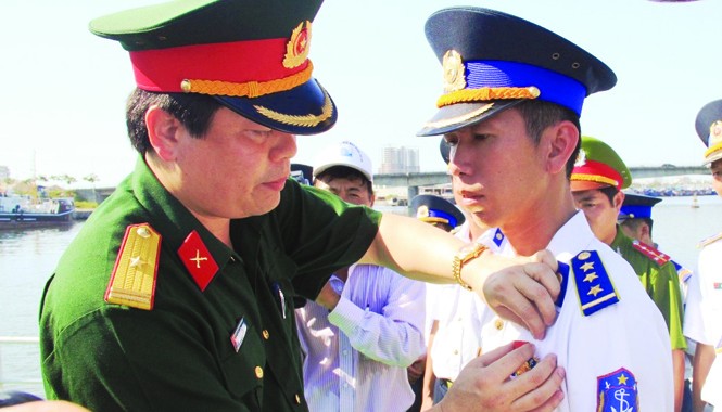 Thuyền trưởng thép trong 'lá chắn' Hoàng Sa Thiếu tá Thái Đức Hạnh trao Huy hiệu “Tuổi trẻ dũng cảm” cho thuyền trưởng Thượng úy Lê Trung Thành. Ảnh: Nguyễn Huy.
