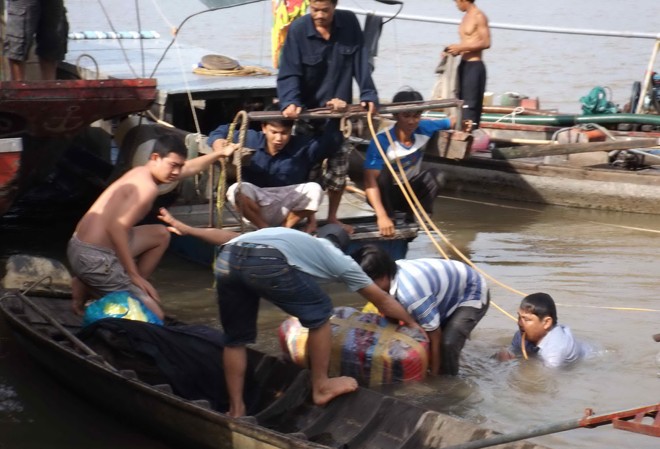 Nổ tàu 60 tấn trên sông Trục vớt hàng hóa trên tàu chìm. Ảnh: Hòa Hội