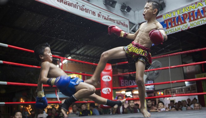 Trẻ em Thái Lan vật vã mưu sinh trên võ đài khốc liệt Một trận đấu giữa hai võ sĩ nhí tại khán đàn Thapae, thành phố Chiang Mai.