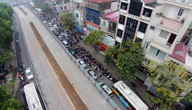 Hà Nội yêu cầu tháo dỡ 'lô cốt' trước Tết Dọc tuyến đường Cầu Giấy, Xuân Thuỷ, nơi đang thi công ga số 6, 7 tuyến đường sắt trên cao cũng thường xuyên xảy ra ùn tắc. Lòng đường chỉ vừa chiếc xe buýt do công trình được quay tôn chiếm nửa đường. Ảnh: Lê Hiếu - Mạnh Thắng.