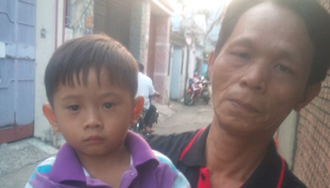 TPHCM: Bé trai 3 tuổi bị lạc đang cần tìm người thân Anh Thanh bảo vệ dân phố đang bế cháu bé. Ảnh: Phùng Bắc.