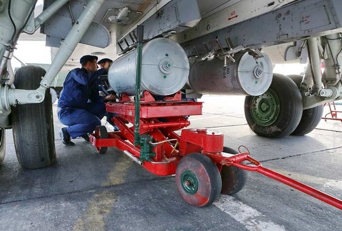 Tận thấy cường kích Su-24 Nga 'lắp cung, đeo kiếm' Các kĩ thuật viên không quân Nga đang lắp quả bom lên giá treo bụng máy bay cường kích Su-24 tham gia cuộc tập trận.